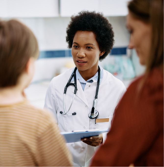 physician with stethoscope around neck speaking to two people