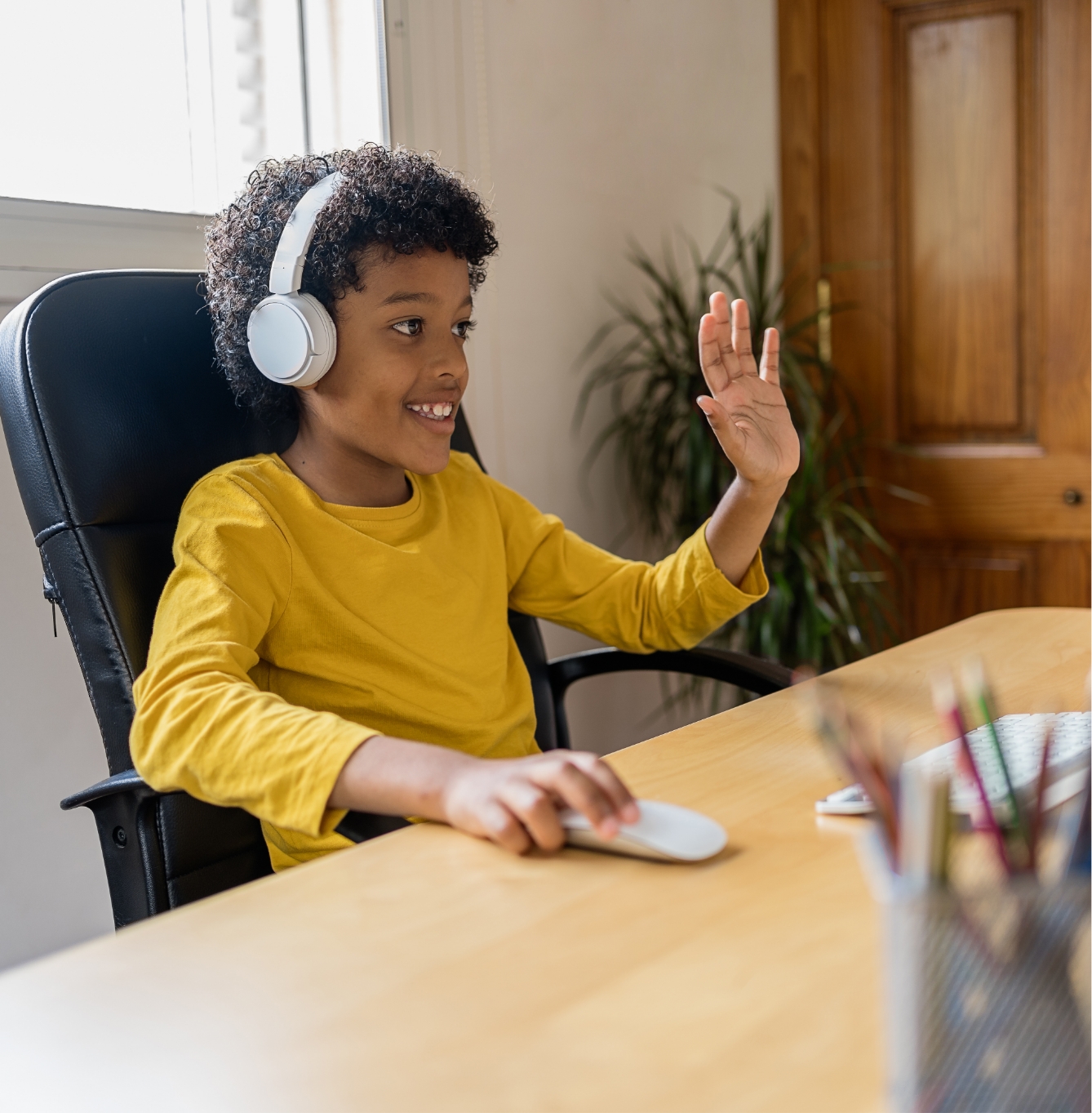 smiling boy operating mouse on desktop computer