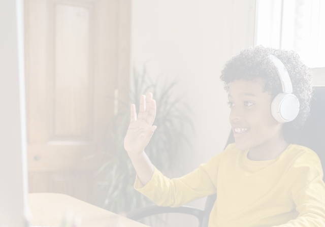 smiling boy operating mouse on desktop computer