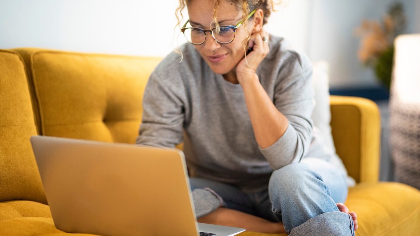 Woman researching on laptop on the couch
