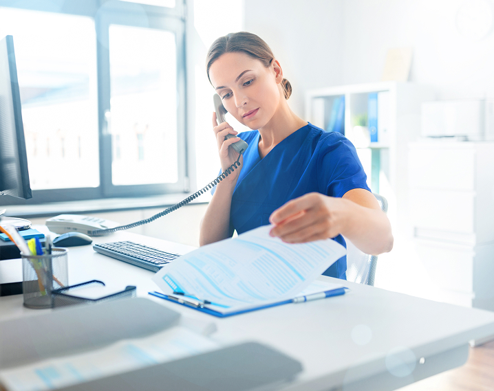 Health care provider at hospital work station on phone