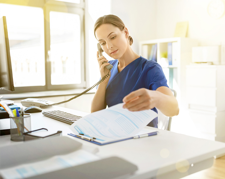 Health care provider at hospital work station on phone