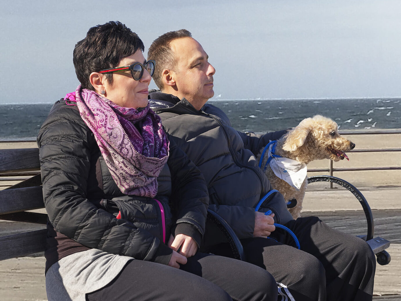 Kristina, a patient living with LEMs sitting on a bench at the beach